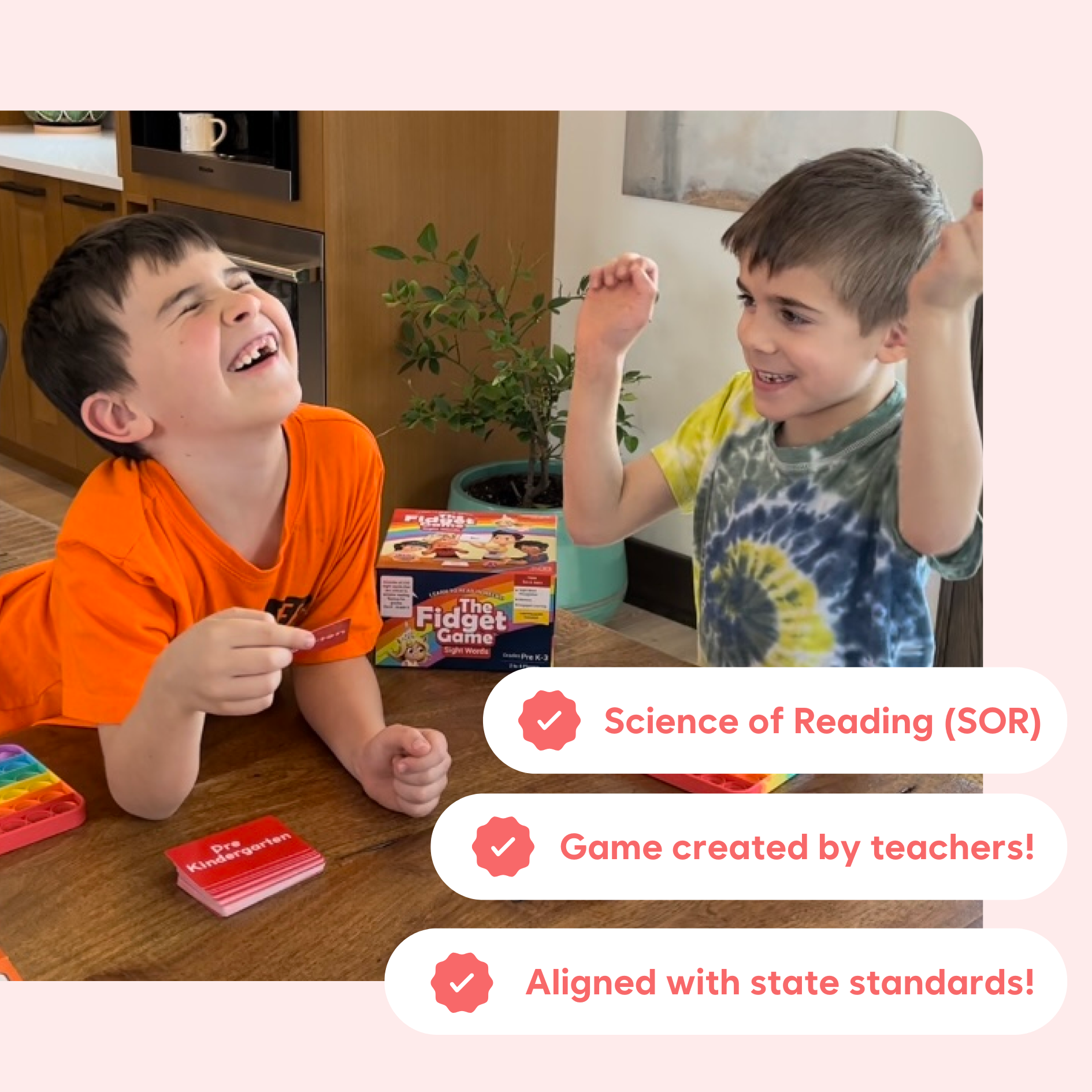 Two boys playing The Fidget Game: Sight Words Edition, laughing and engaging with colorful cards in a bright room.