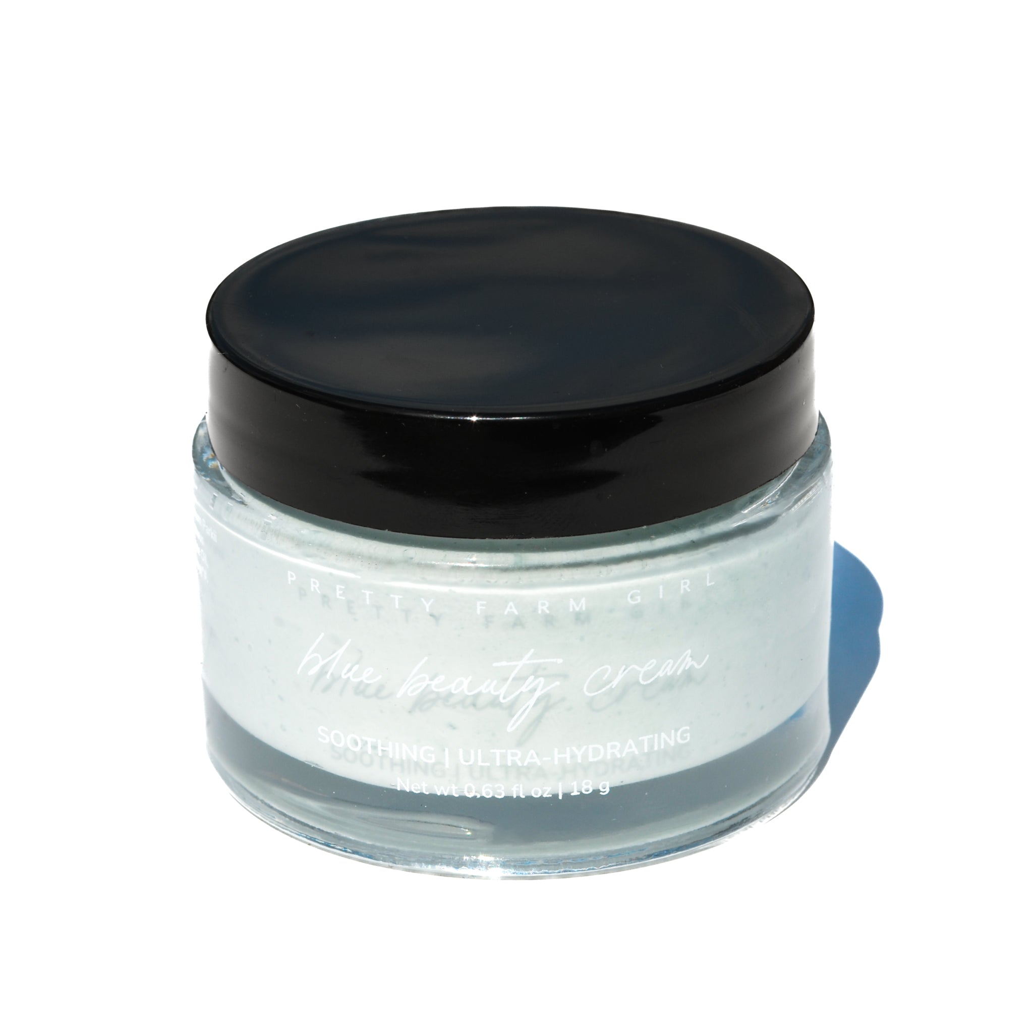 Blue Beauty Cream Soothing Tallow Face Cream in a clear jar with a black lid, featuring a light blue cream inside.